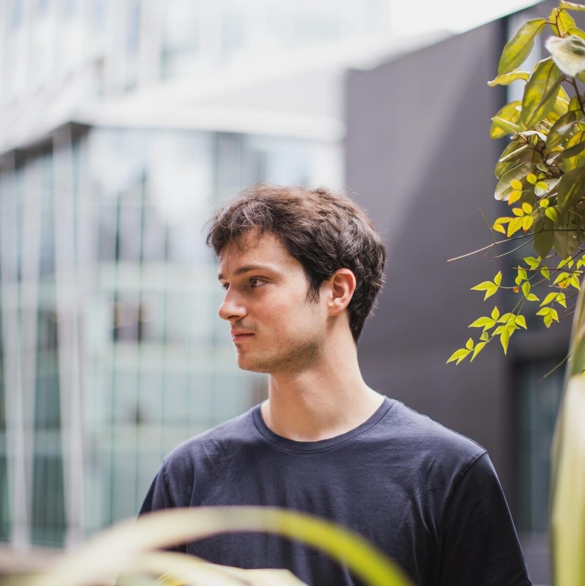 Lior Solomons Wise 2025 A head and shoulders profile of Pianist Lior Solomons-Wise against a blurry urban background. He is dressed casually in a grey sweatshirt