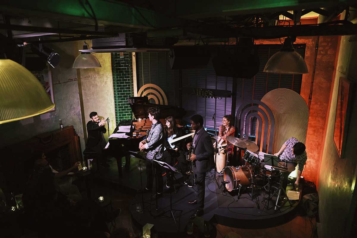 A long shot in a jazz club, the latin collective are onstage, you can't see the audience<br />
 